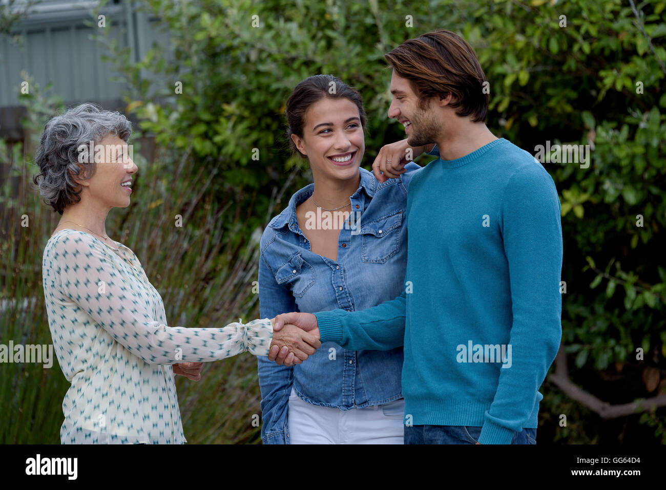 Glücklich Reife Frau treffen mit jungen Paar außerhalb Stockfoto