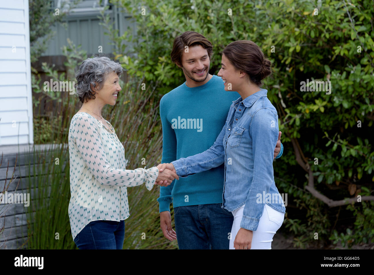 Glücklich Reife Frau treffen mit jungen Paar außerhalb Stockfoto