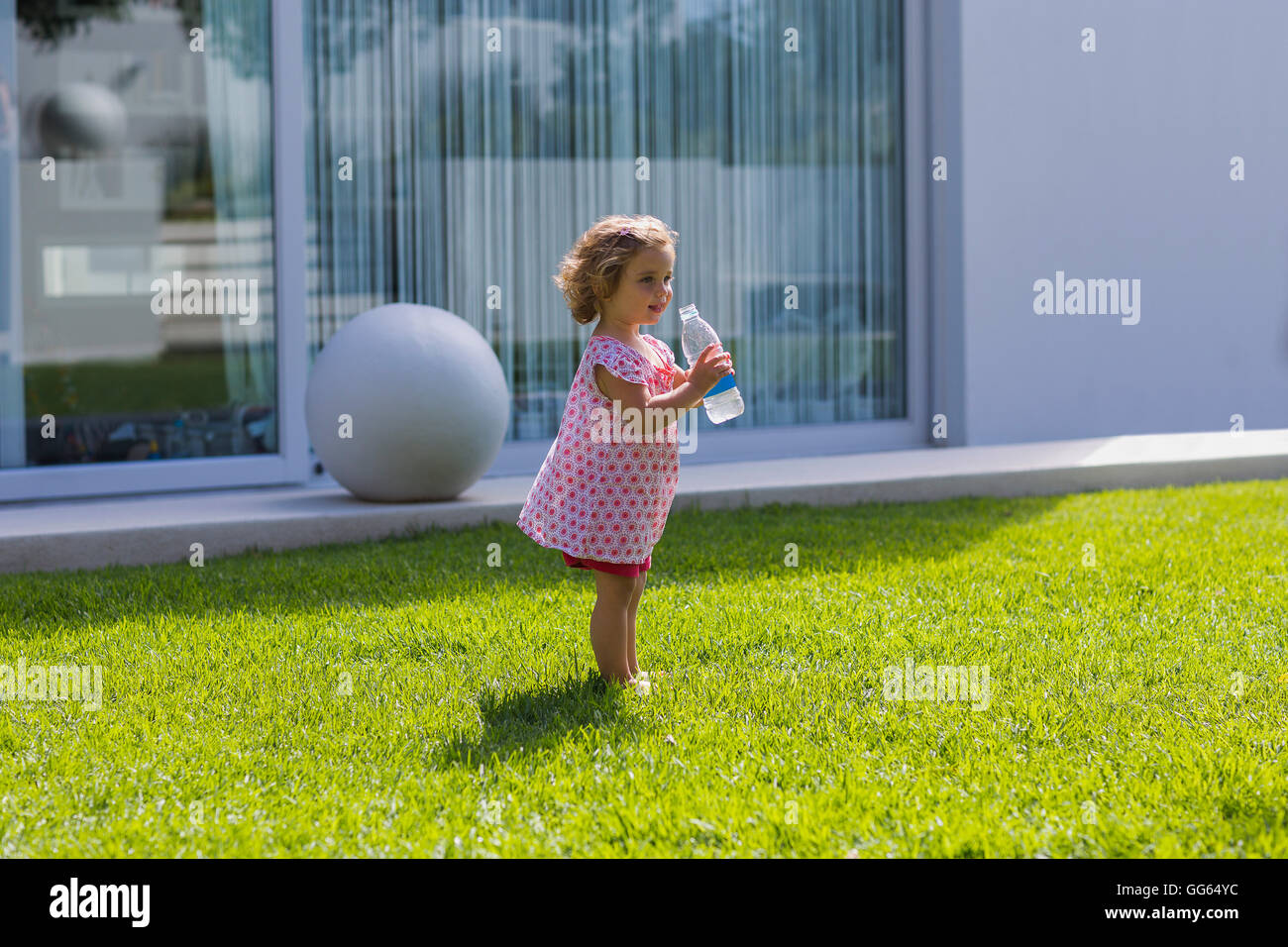 Baby Mädchen Trinkwasser aus einer Flasche Stockfoto