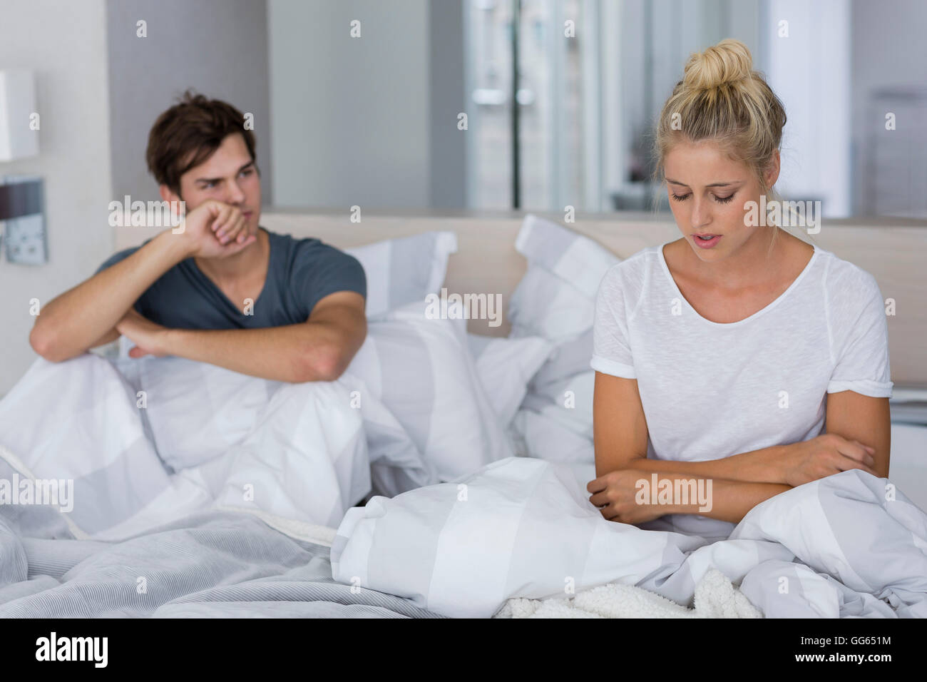 Junges Paar sitzt auf dem Bett mit Beziehungsschwierigkeiten Stockfoto