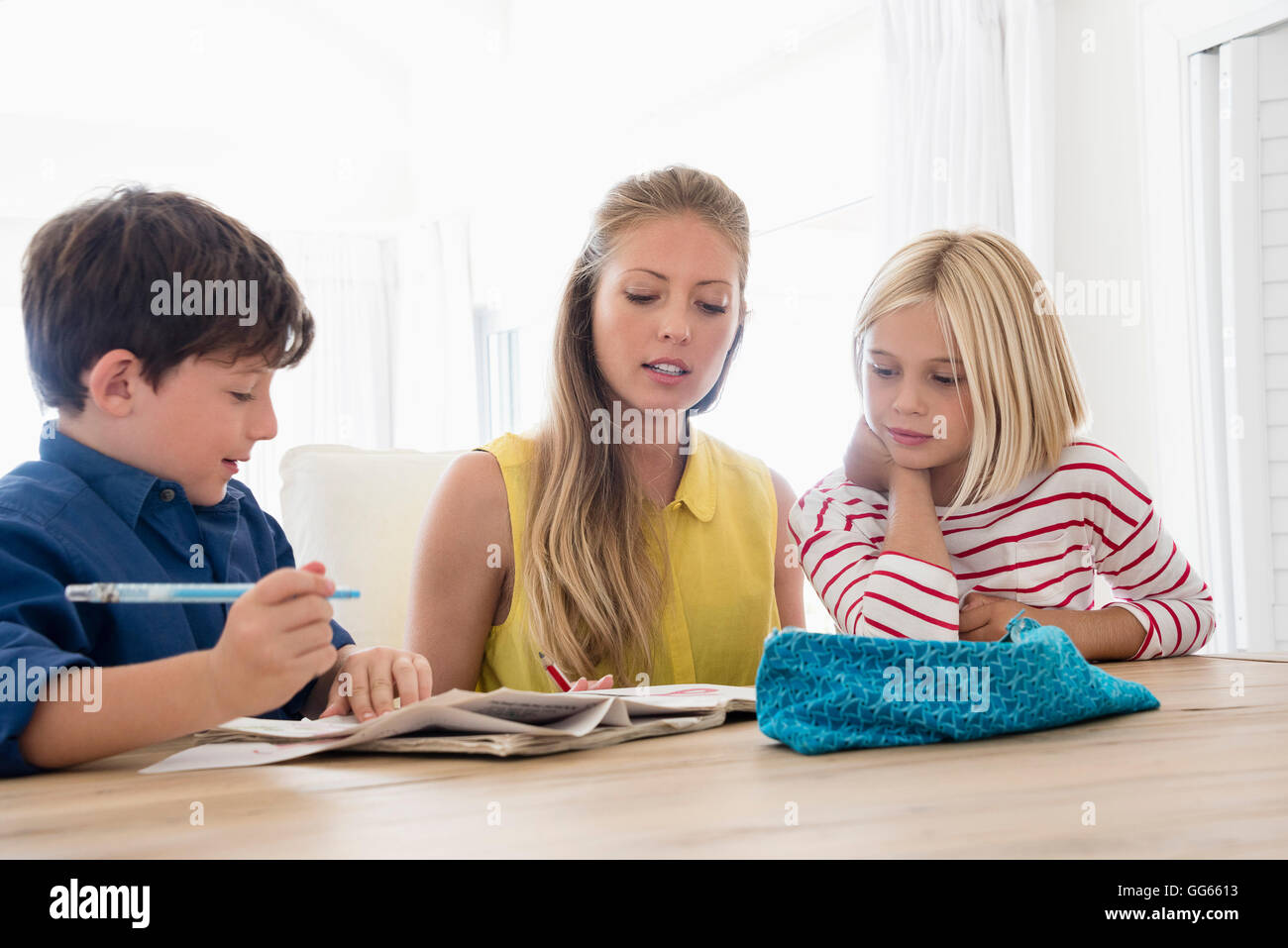 Mutter und Kinder Hausaufgaben auf Tisch Stockfoto