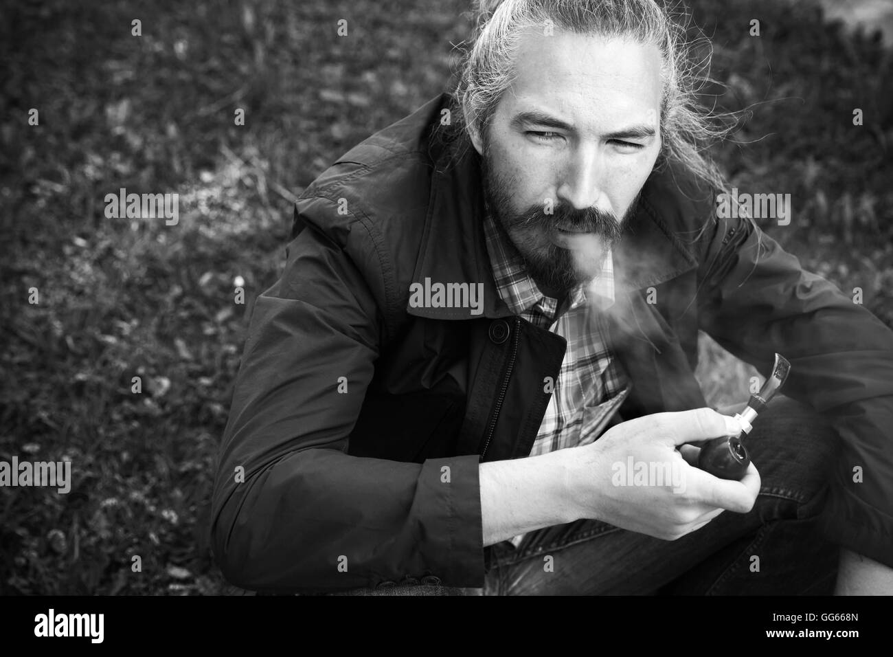 Asiatischer Mann Rauchen einer Pfeife, schwarz / weiß Foto mit selektiven Fokus Stockfoto