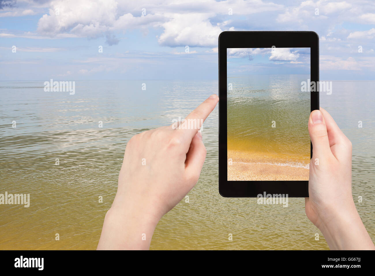 Reisekonzept - Tourist Fotos der ruhigen Oberfläche des Asowschen Meeres auf TabletPC Stockfoto