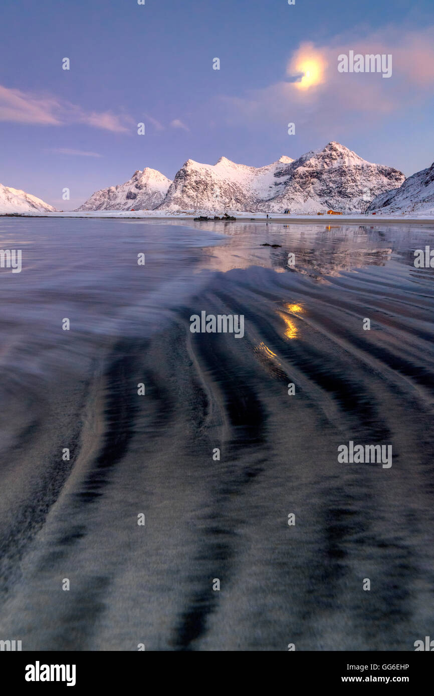 Vollmond spiegelt sich in der eisigen Meer rund um die surreale Skagsanden Strand, Flakstad, Nordland Grafschaft, Lofoten Inseln, Norwegen Stockfoto