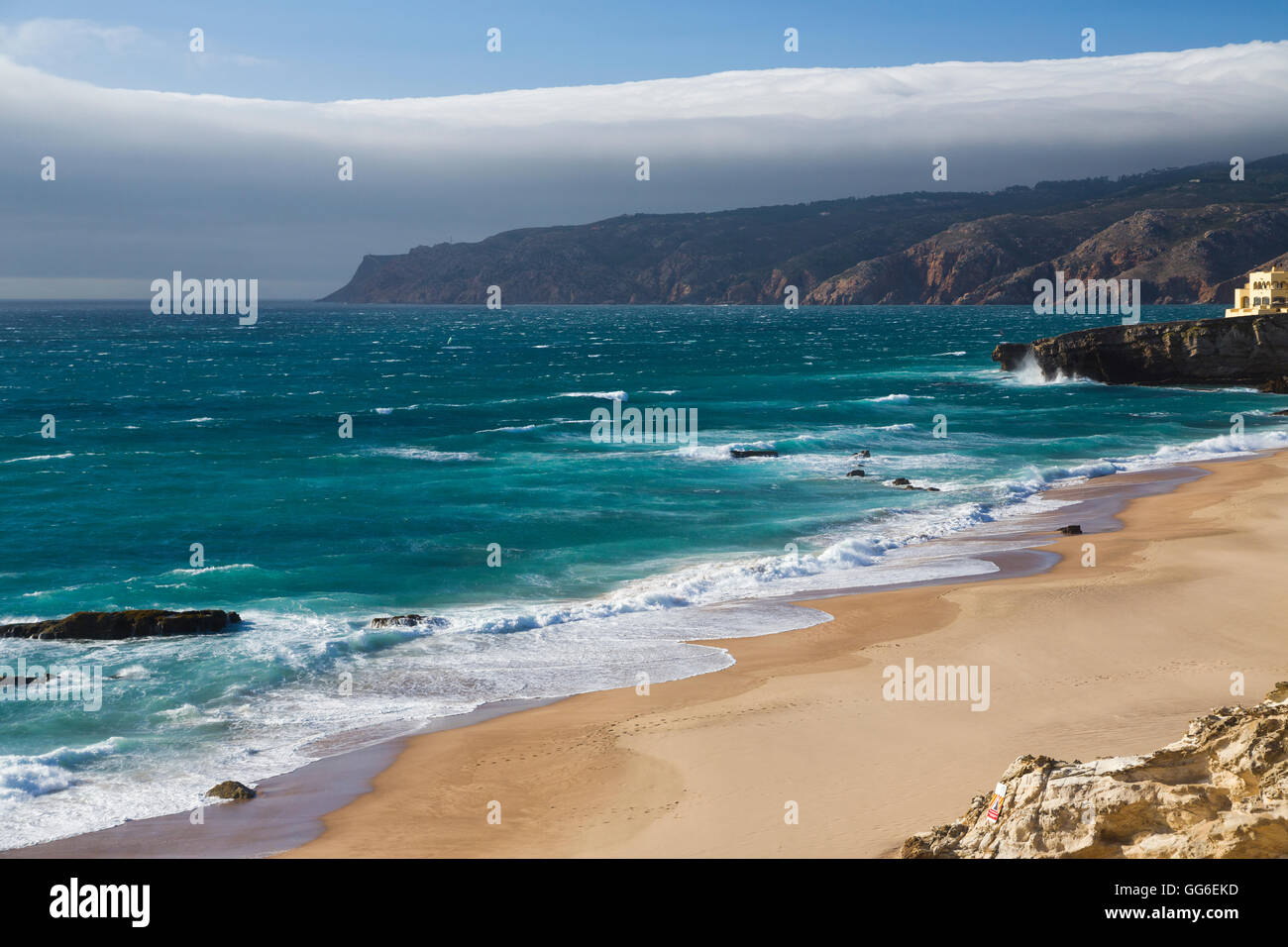 Ozean-Wellen, die auf dem sandigen Strand von Cascais, umgeben von Klippen, Küste von Estoril, Lissabon, Portugal, Europa Stockfoto
