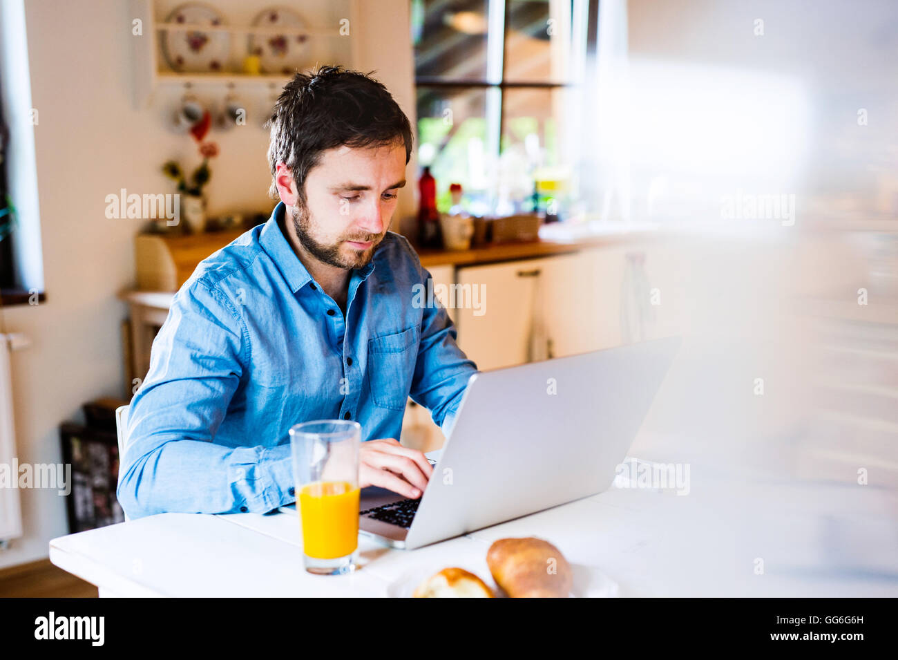 Mann am Schreibtisch arbeiten von zu Hause aus auf laptop Stockfoto