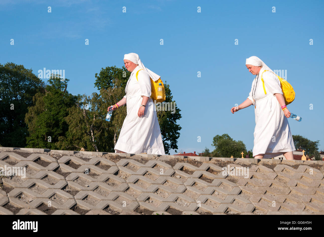Weltjugendtag 2016. Zwei Frauen, weibliche Pilger, Nonnen in weißen Gewohnheiten zu Fuß entlang dem Flußdamm mit gelben Rucksäcke Stockfoto
