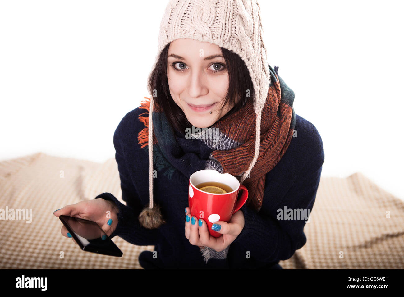 Frau eine große Tasse frisch gebrühtem Tee genießen, wie sie auf dem Sofa im Wohnzimmer entspannt Stockfoto