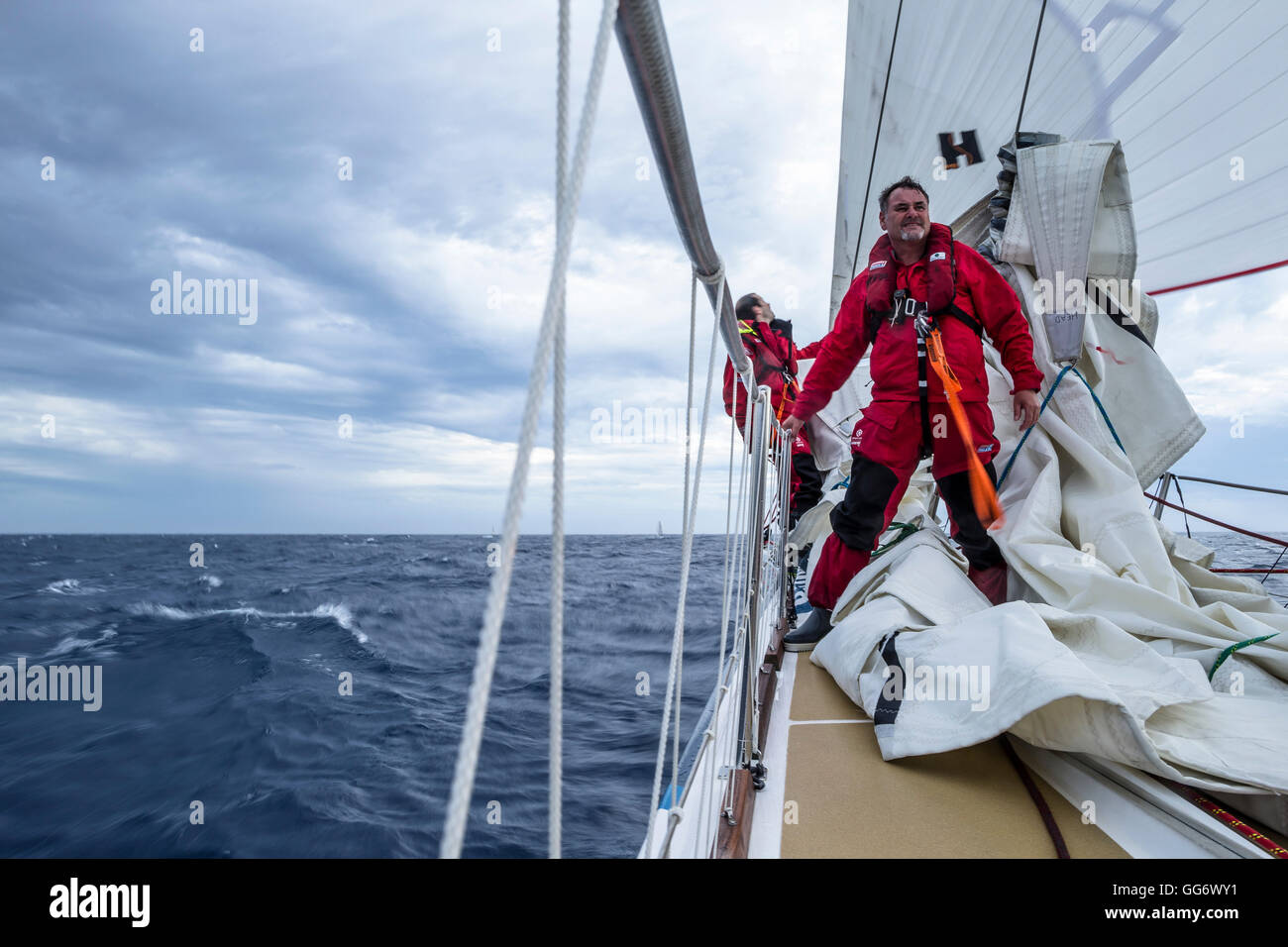 Rennen-Konkurrent steht Warnung an Deck während der Clipper Round the World Yacht Race. Stockfoto
