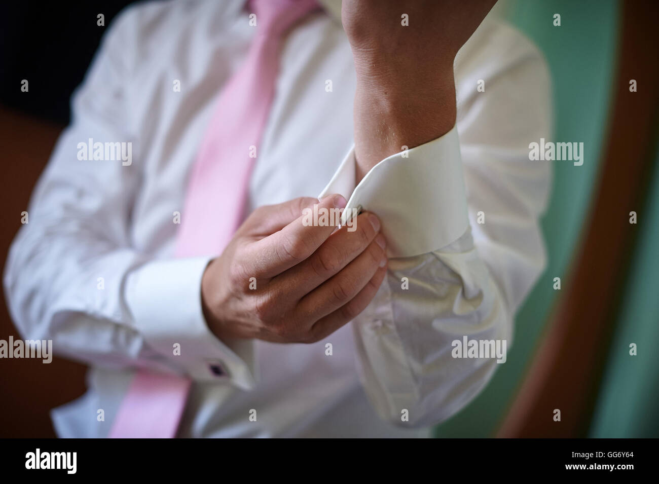Mann in weißen Hemd mit rosa Krawatte in der Nähe von Fenster-Kleid-Manschettenknöpfe Stockfoto