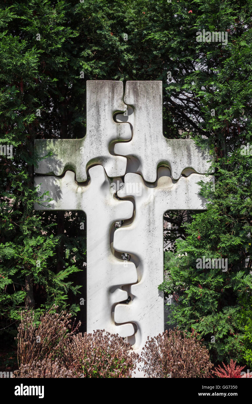 Steinkreuz geformte Knochen/Puzzle, umgeben von den Friedhof Garten. Stockfoto