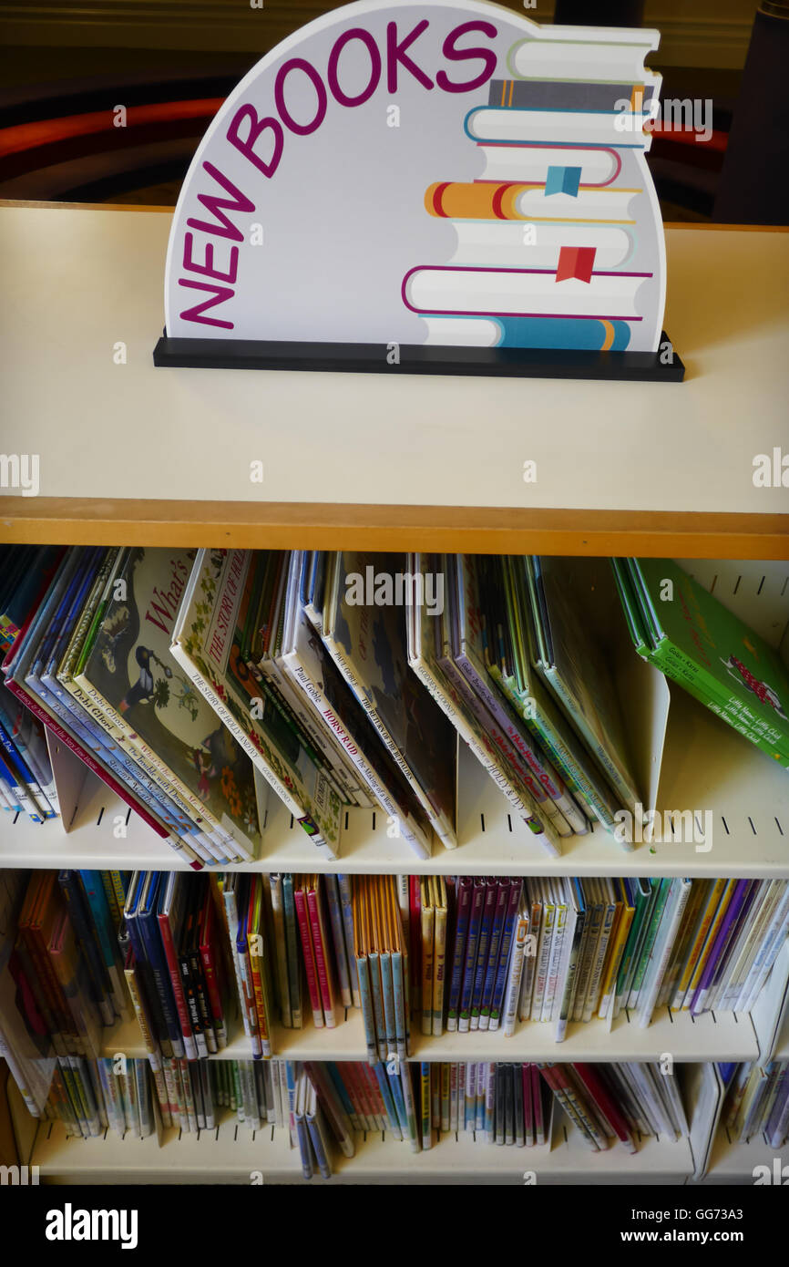 Neue Kinderbücher auf dem Display auf dem neuen Bücher-Gestell in einer öffentlichen Bibliothek. Stockfoto