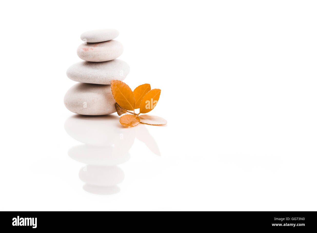 Haufen Ausgleich Kiesel Steinen und orange Blatt, wie ZEN Stone, isoliert auf weißem Hintergrund, Spa Wellness ruhige Szene Konzeptionierung Stockfoto