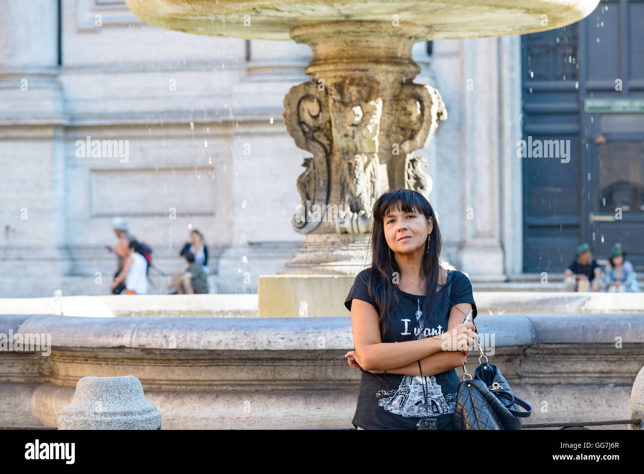Mädchen posiert unter einem Brunnen in Rom, Italien Stockfoto