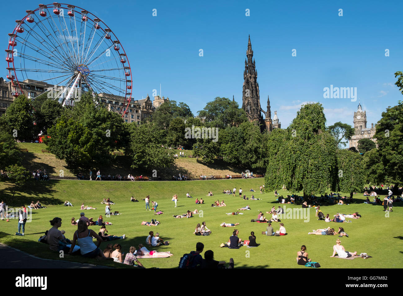 Heißes Sommerwetter bringt viele Menschen in Princes Street Gardens in Edinburgh, Schottland, Vereinigtes Königreich Stockfoto