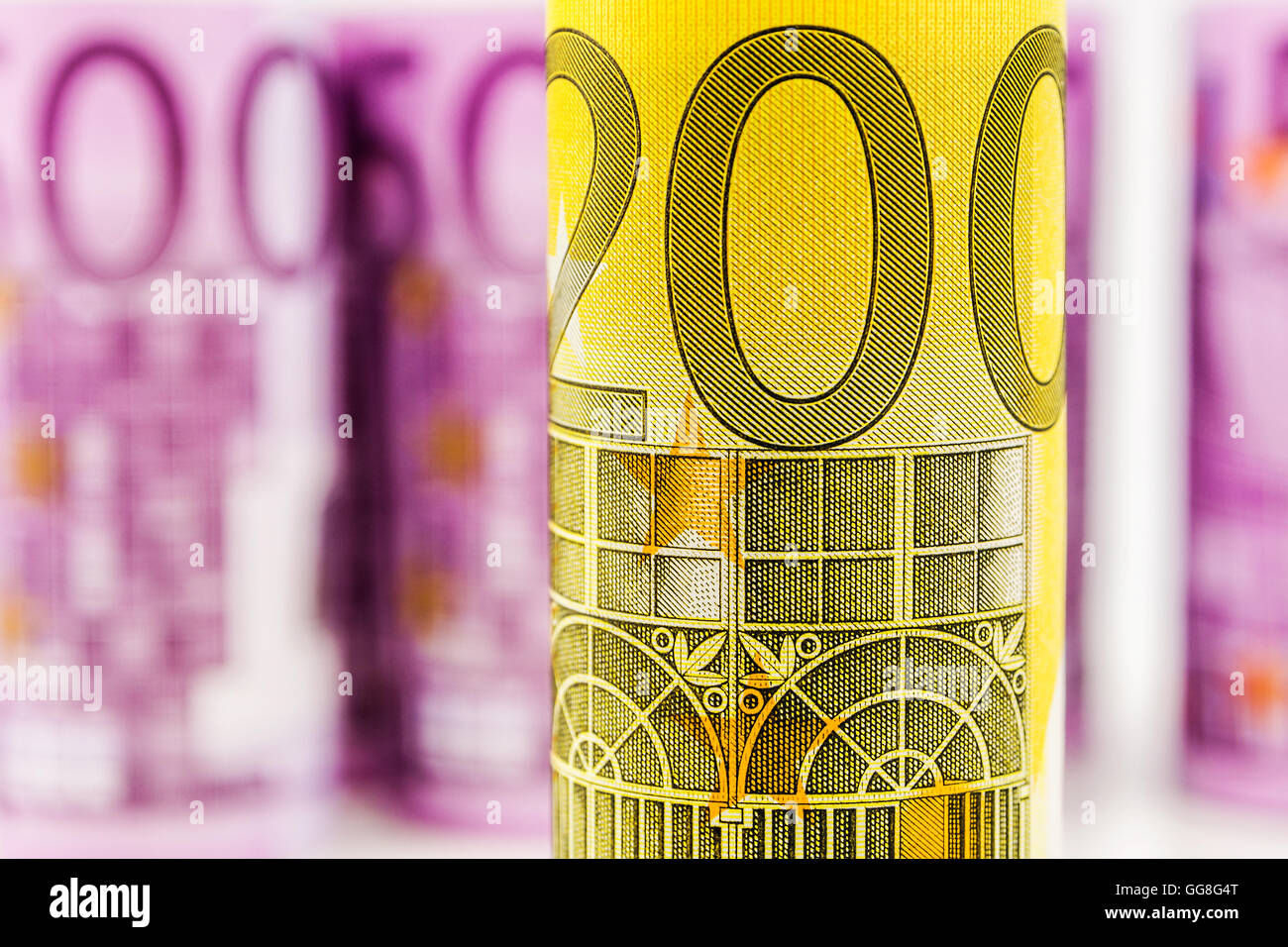 Detailansicht von 200 Euro gerollt Banknote mit dem Hintergrund gemacht von einem anderen 500 Euro-Banknoten verschwommen und aufgerollt Stockfoto