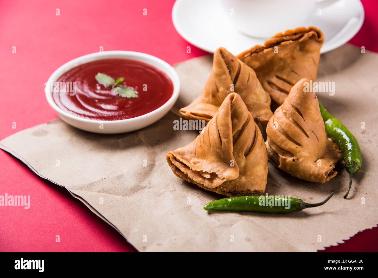 Samosa-Snack mit Tomaten-Ketchup und heißen Tee, frische Samosas mit Ketchup und bereit zum Frühstück heißen chai Stockfoto