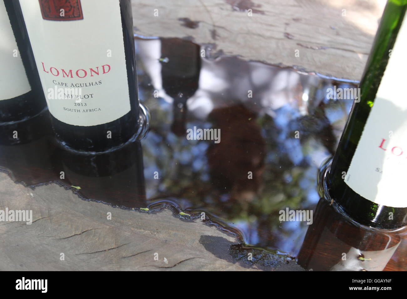 Flaschen auf einen Tisch stehend im Wasser bei Lomond Wines, Kap Agulhas, Südafrika Stockfoto