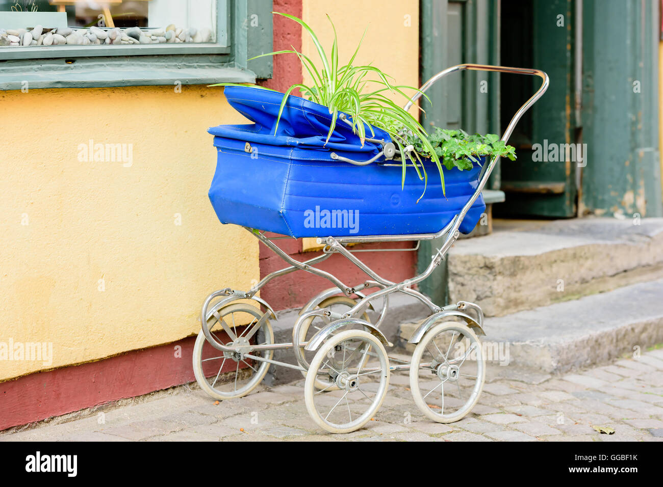 Alte, getaktete Kinderwagen, jetzt als mobile Blumenbeet genutzt.  Alternative im Garten in der Stadt Stockfotografie - Alamy