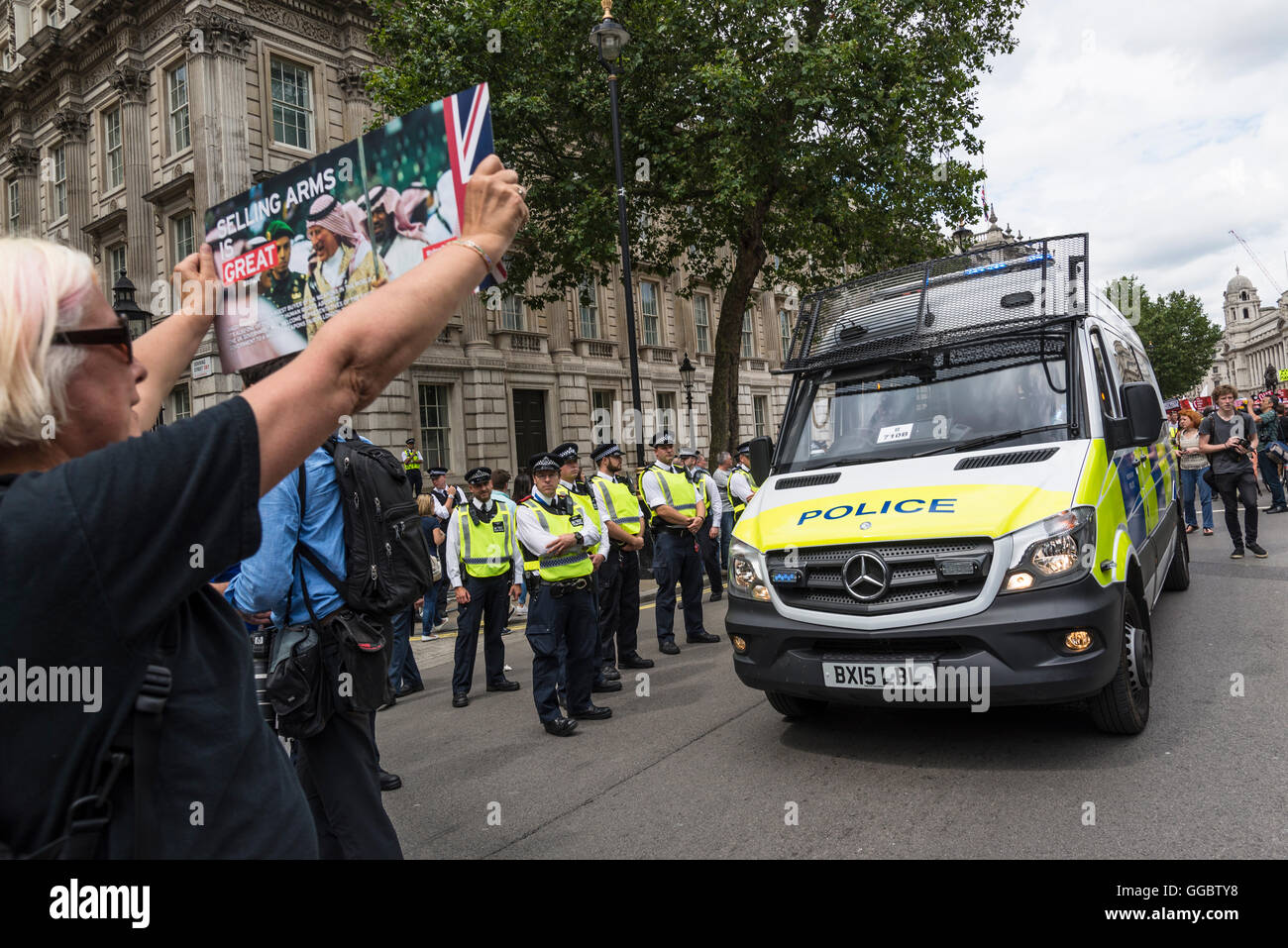 Frau mit Plakat vor Polizei van, nein mehr Sparmaßnahmen - Nein zu Rassismus - Tories müssen gehen, London, Vereinigtes Königreich, UK Stockfoto