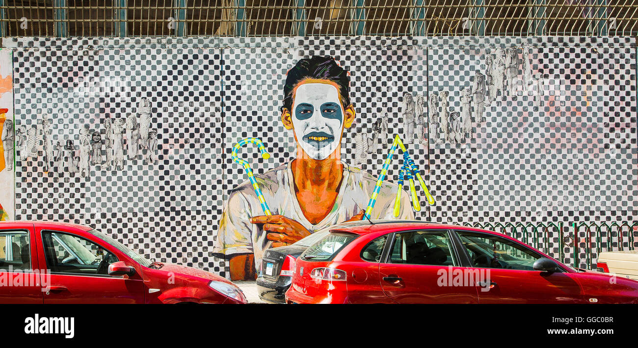 Ägypten, Kairo, Graffiti der ägyptischen Revolution. Junger Mann mit einer Clownsmaske vor einem großen Schachbrett. Stockfoto