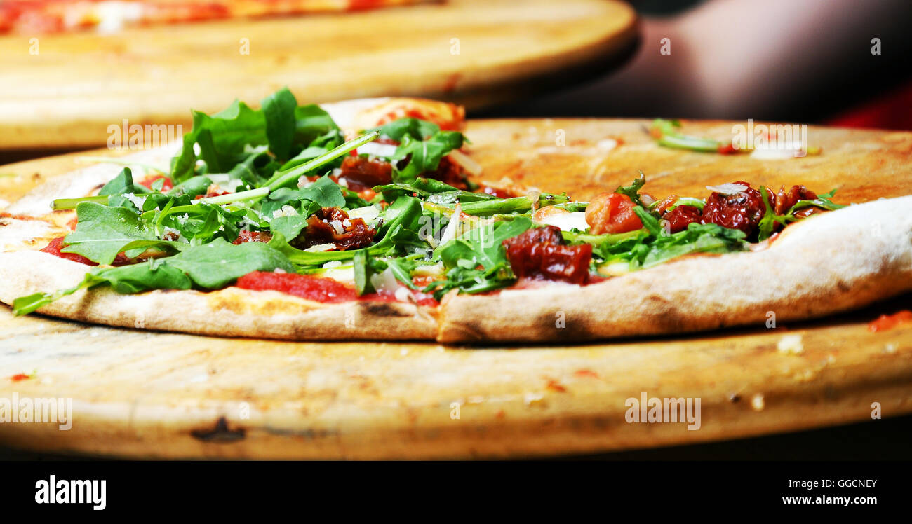 Prague Charles Square Tag italienische Küche Pizza Pizza mit Rucola auf einer hölzernen Schneidebrett Stockfoto