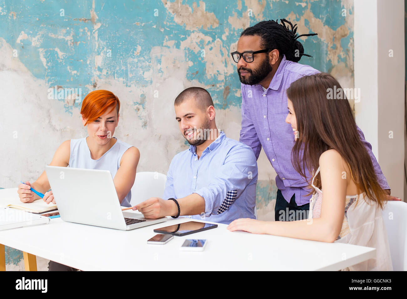 Junge Menschen arbeiten am Schreibtisch im Büro grunge Stockfoto
