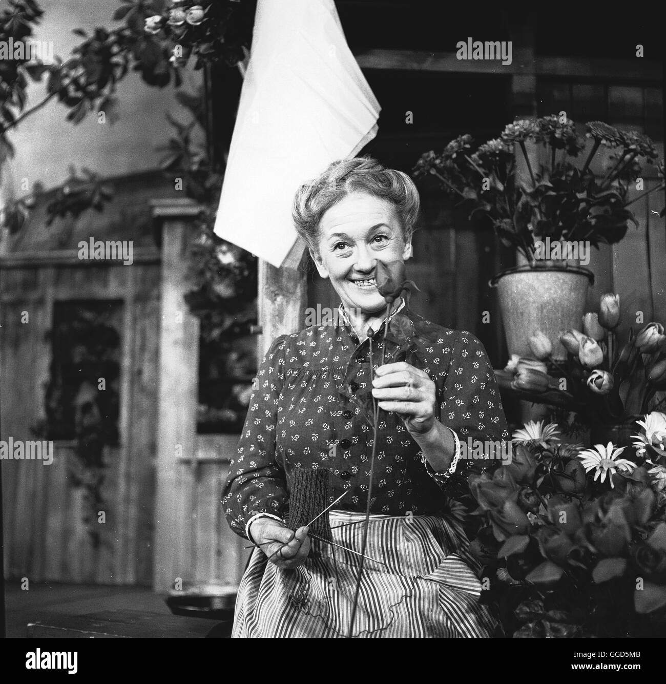 DER KOMÖDIENSTADEL: GRAF SCHORSCHI / BRD 1962 / Olf Fischer ERNI SINGERL als Köchin Theres Am Viktualienmarkt in München Hat Frau Graf Ihren Blumen-Und Gemüsestand. SCHORSCHI, Ihr Sohn, Hilft der Mutter. Von Beruf ist er Gärtner. Zu Den Kunden Gehört Die Familie Schrumm, sterben Tochter Bertl, der Vater Und Die Mutter. Vor Allem Frau Schrumm ist Sehr weltweit, Denn Sie Erwartet Einen Grafen Bei Sich Zu Hause. Zwischen Bertl Und Schorschi Aber Spinnen Sich sterben Küchenteam Fäden Einer Zuneigung. Wie es Das Schicksal will, shall Schorschi, der Für Einen Feierlichen Anlass Entsprechend Angezogen ist, Stockfoto