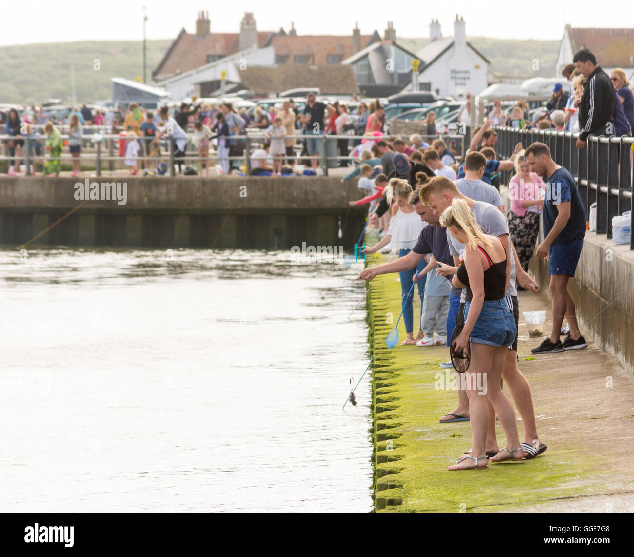 Krabben fangen oder Verdrehungen, ist eine beliebte Sommeraktivität Wochenende für Jung und alt am Mudeford Quay, Dorset, UK. Stockfoto