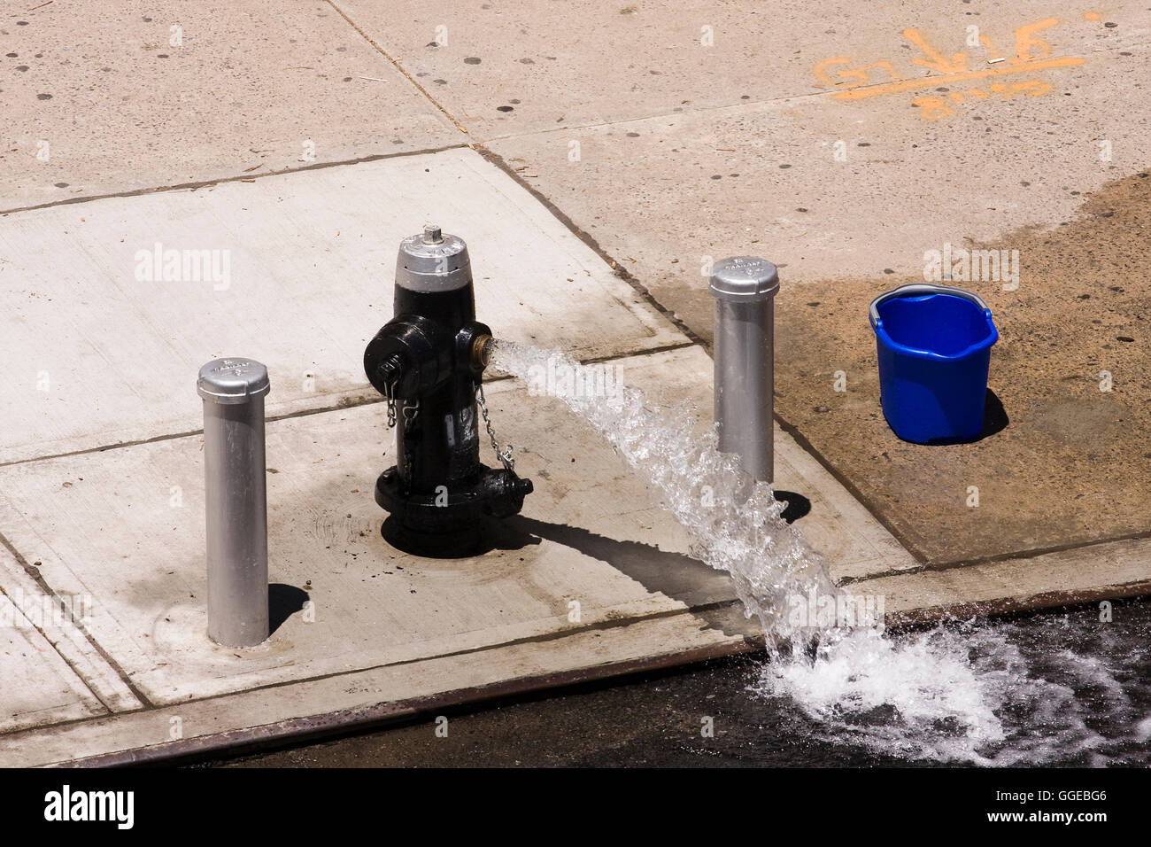 Offenen Hydranten auf dem Bürgersteig schießt einen Strom von Wasser in der Straße an einem heißen Sommertag Stockfoto
