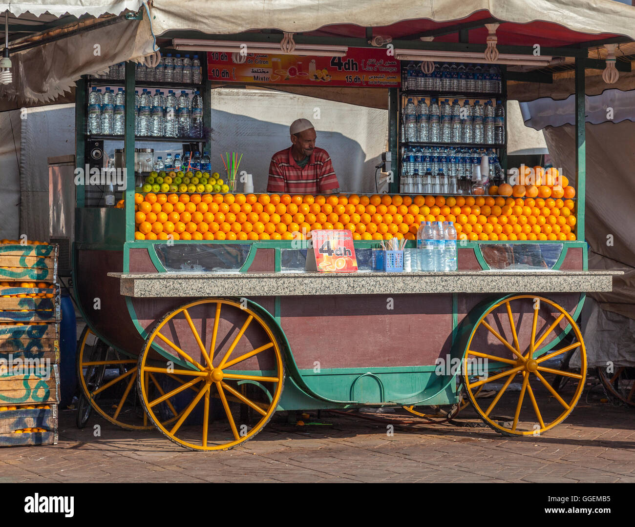 Saft von Zitrusfrüchten Verkäufer mit seinem Stall, bestückt mit Orangen, Grapefruit, Zitrone und Wasser in Flaschen in Jamaa el Fna. Stockfoto