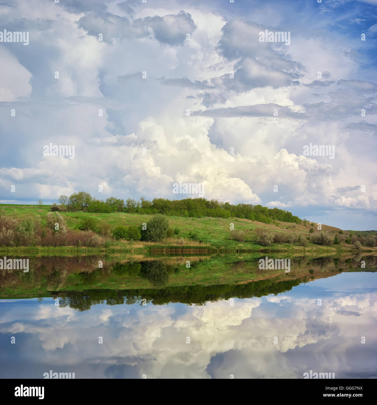 Schöner See, Frühlingswiese und bewölktem Himmel Stockfoto