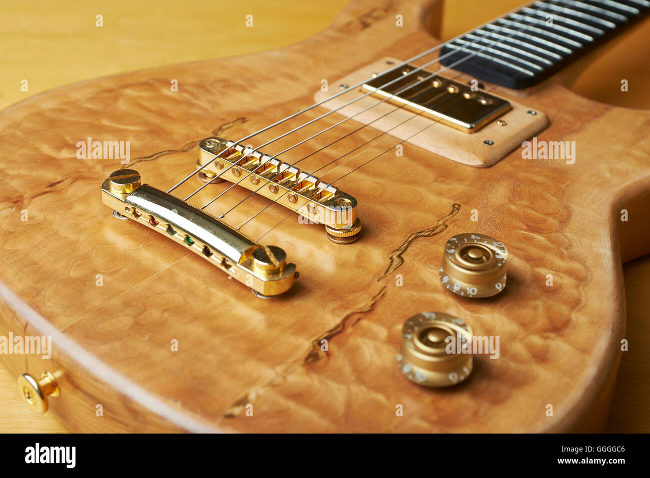 Gitarre, Holz natürliche Farbe mit goldenen Accessoires. Stockfoto