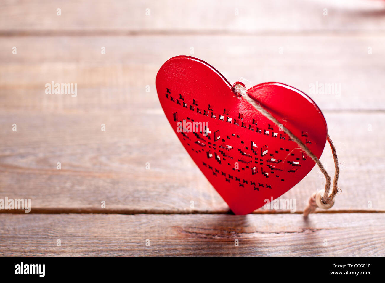 Rotes Herz auf hölzernen Hintergrund. Symbol der Liebe in den Valentinstag. Stockfoto