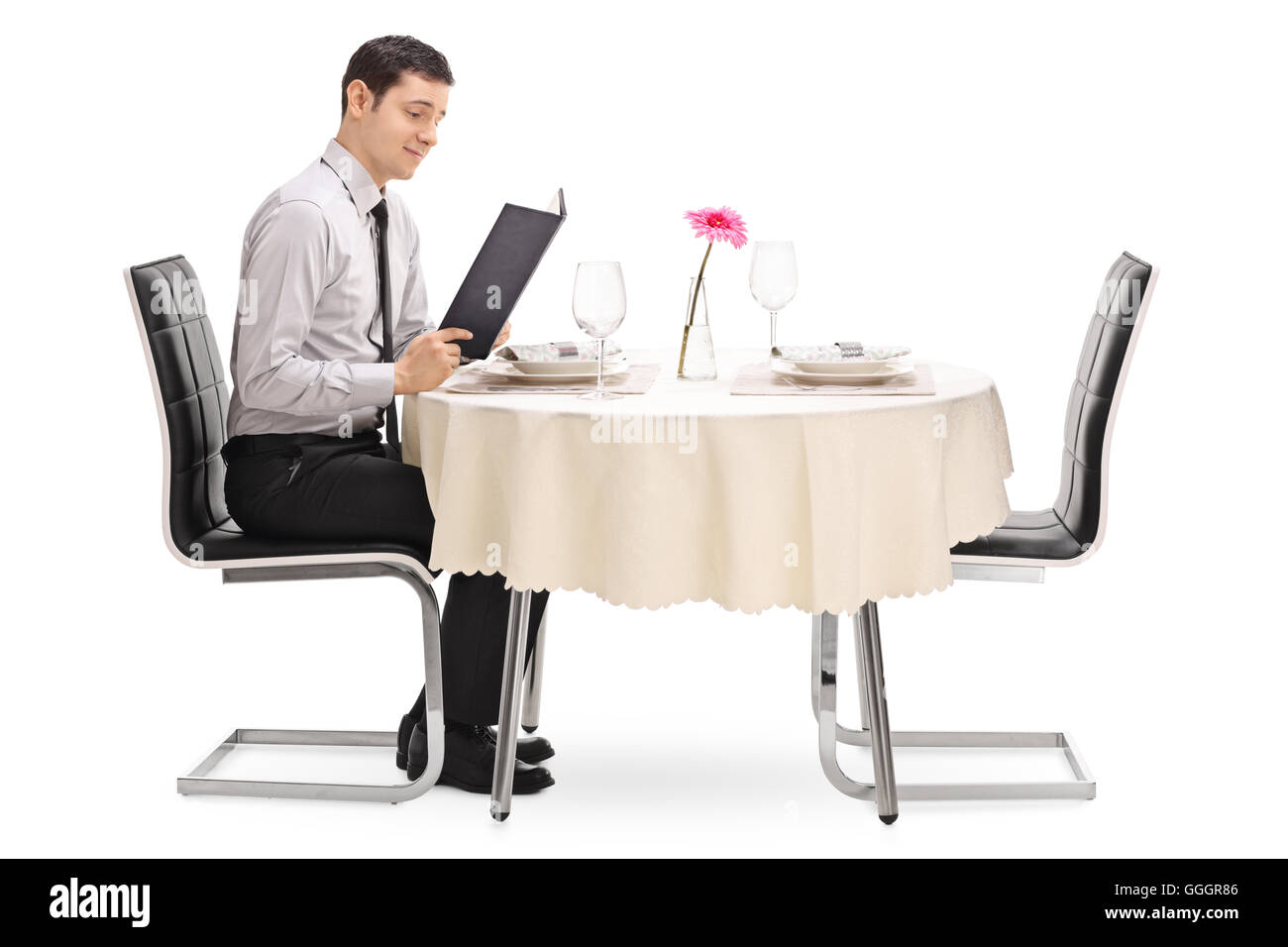 Junger Mann sitzt an einem Tisch im Restaurant und Lesen der Speisekarte isoliert auf weißem Hintergrund Stockfoto