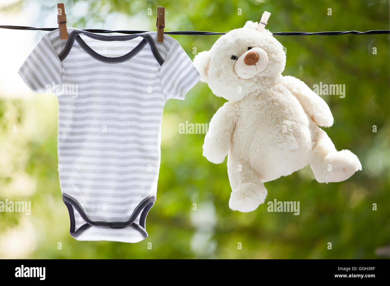 Baby-Kleidung und Teddy Bär aufhängen auf der Wäscheleine - Familienkonzept Stockfoto