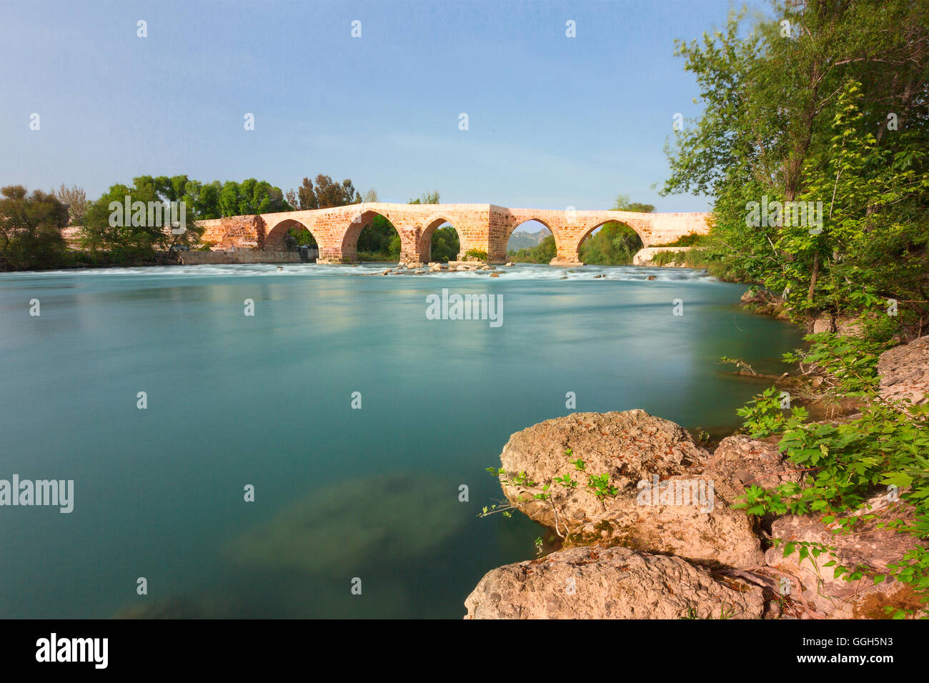 Römische Brücke am Fluss Köprüca in Aspendos, in Antalya, Türkei. Stockfoto
