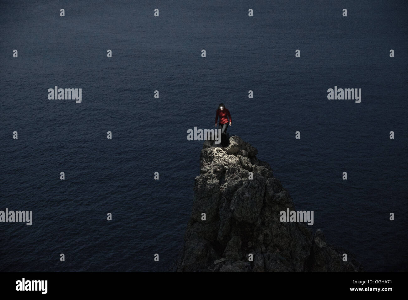 Junge Frau auf einem spitzen Felsen am Meer, Mallorca, Spanien Stockfoto