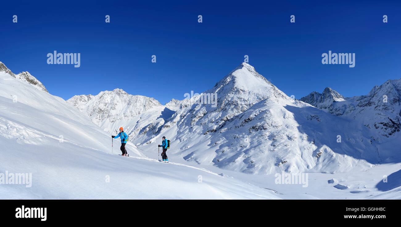 Zwei weibliche Backcountry Skifahrer aufsteigend nach Kuhscheibe, Stubaier Alpen, Tirol, Österreich Stockfoto
