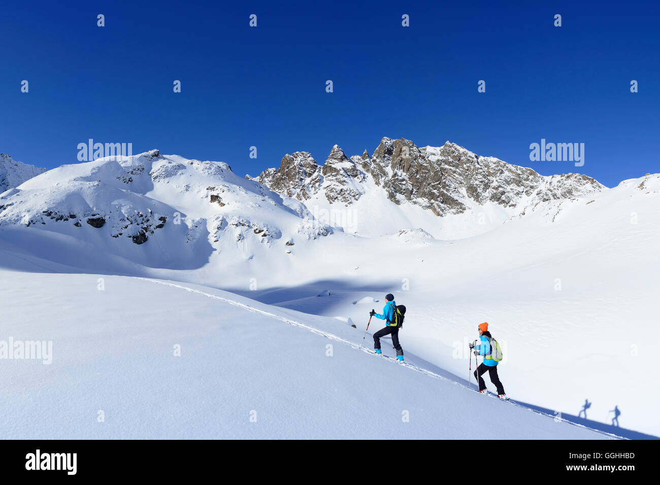 Zwei weibliche Backcountry Skifahrer aufsteigend nach Kuhscheibe, Stubaier Alpen, Tirol, Österreich Stockfoto