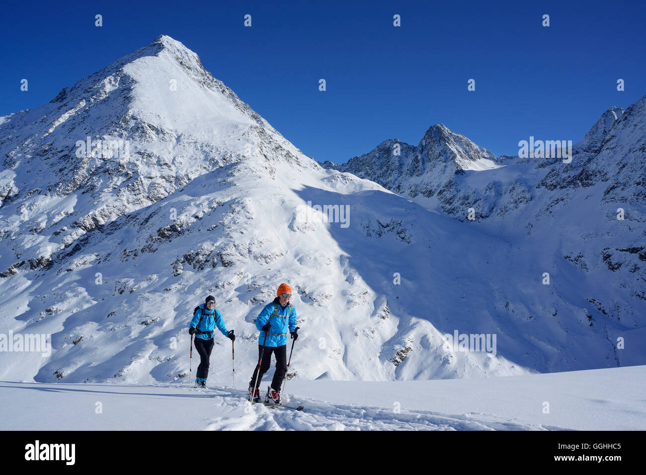 Zwei weibliche Backcountry Skifahrer aufsteigend nach Kuhscheibe, Stubaier Alpen, Tirol, Österreich Stockfoto