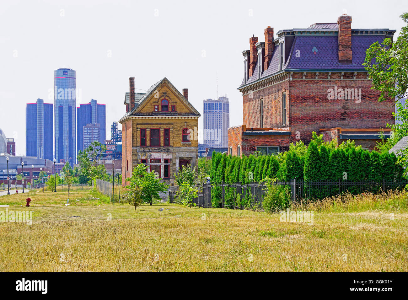 Detroits Bürste Park verbleibenden viktorianischen Häusern und Baulücken mit Downtown Renaissance Center in Ferne. Stockfoto
