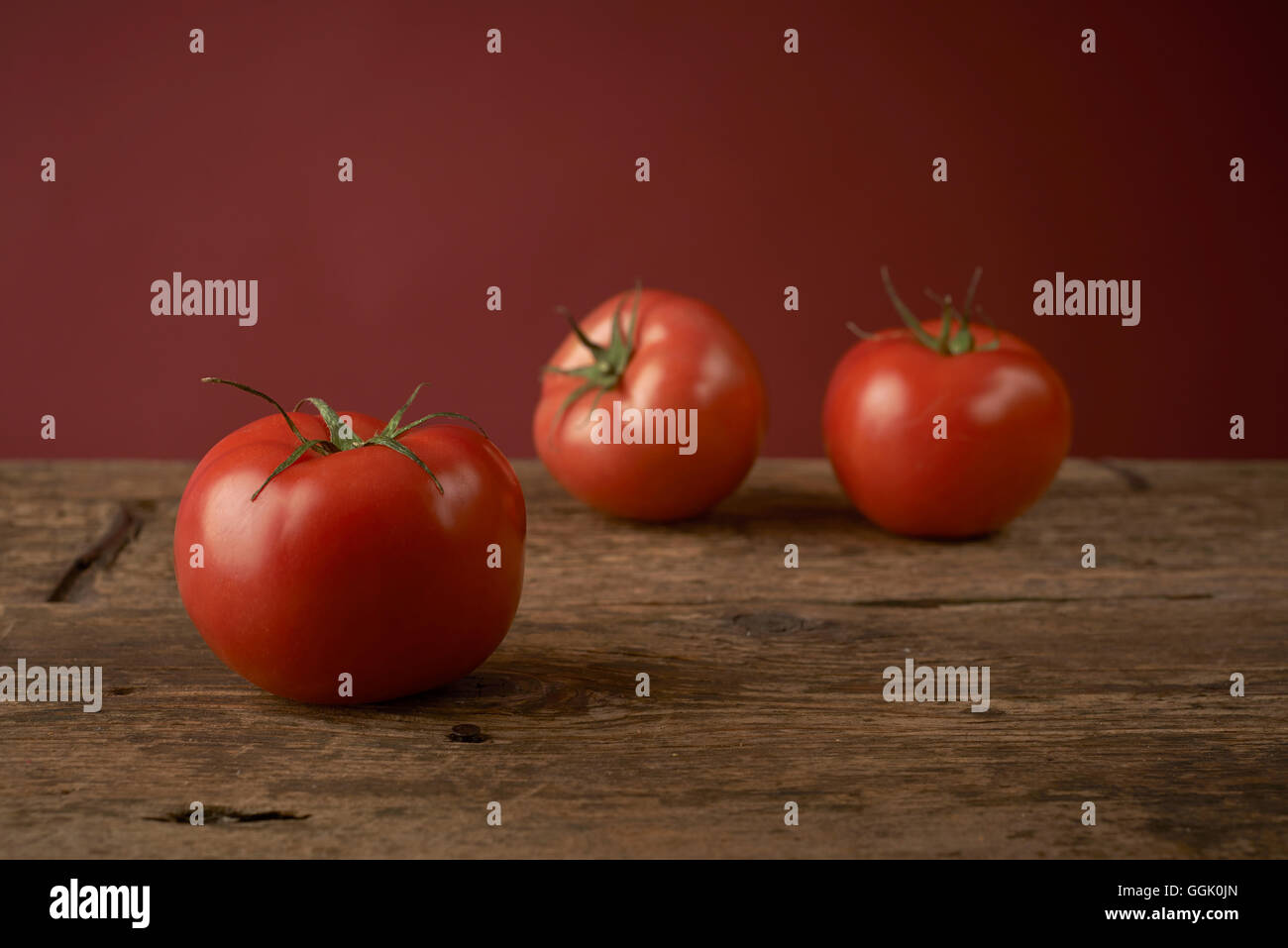 frische rote Tomaten auf einem Holztisch Stockfoto