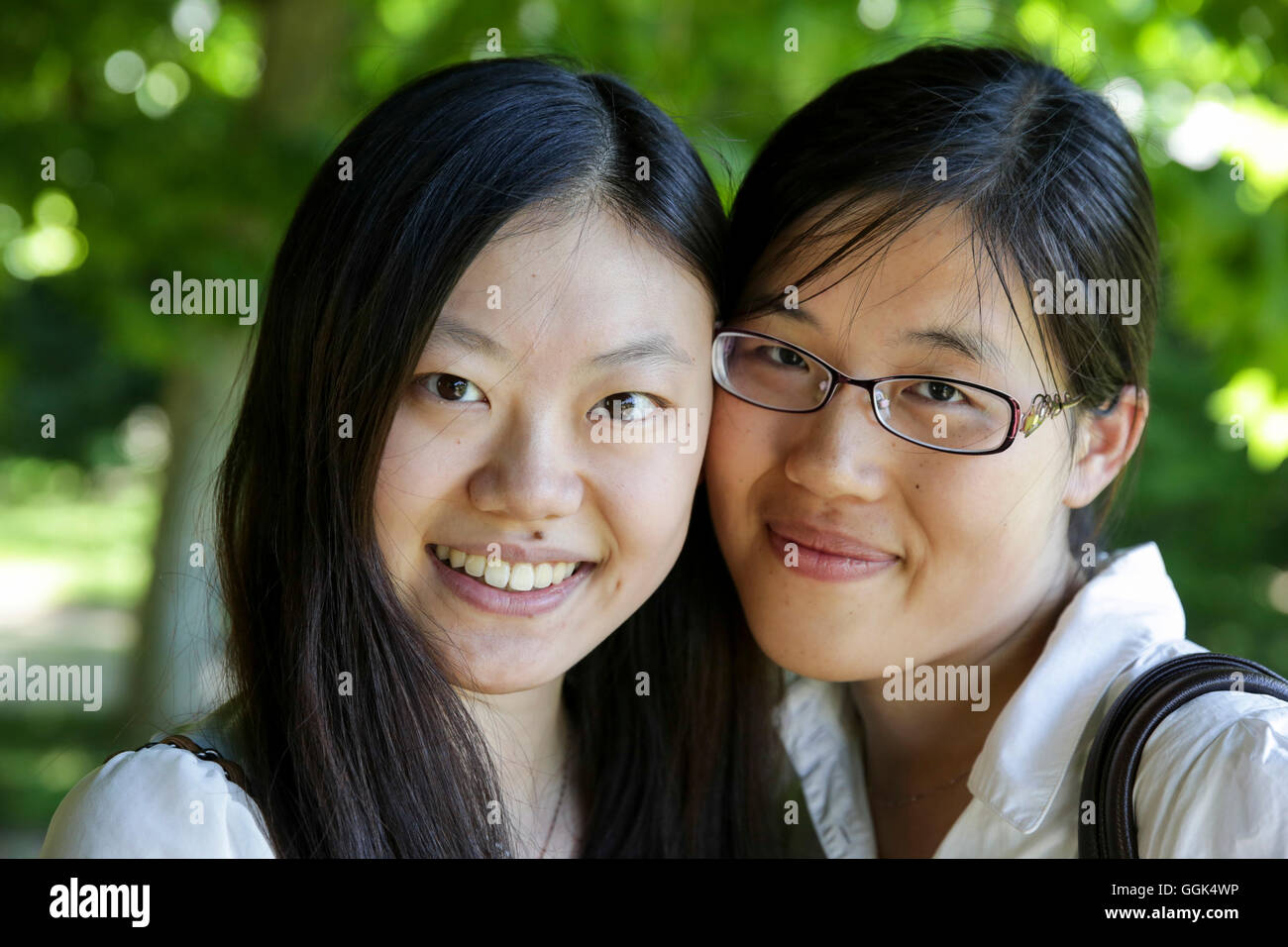 Zwei junge Frauen, die lächelnd in die Kamera, Leipzig, Sachsen, Deutschland Stockfoto