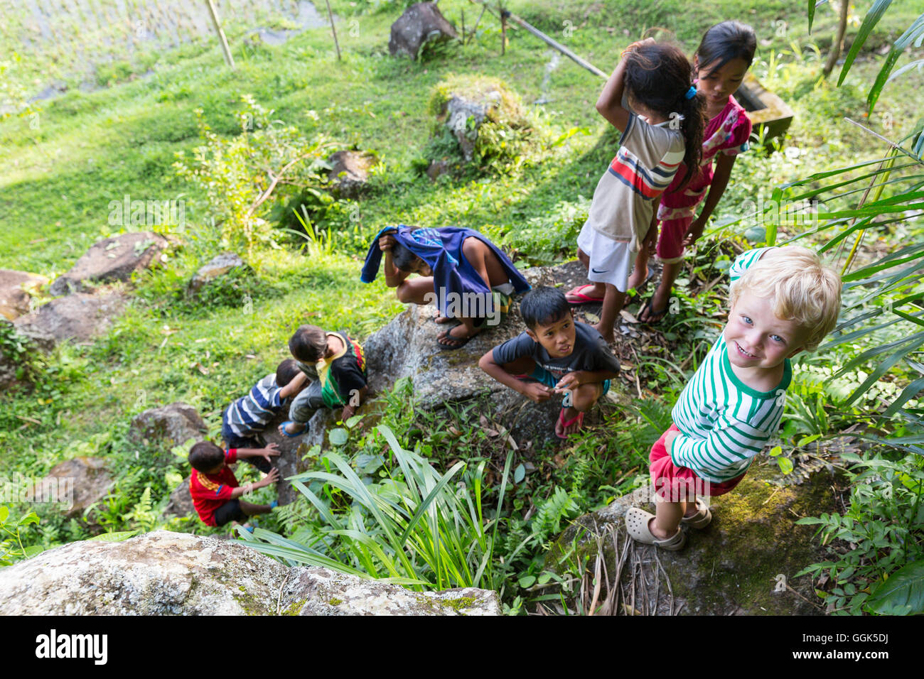 Deutsche Junge spielt mit indonesischen Kinder, kriechen, auf Felsen klettern, junge 3 Jahre alt, Dorf, Landschaft, Kinder, Stockfoto