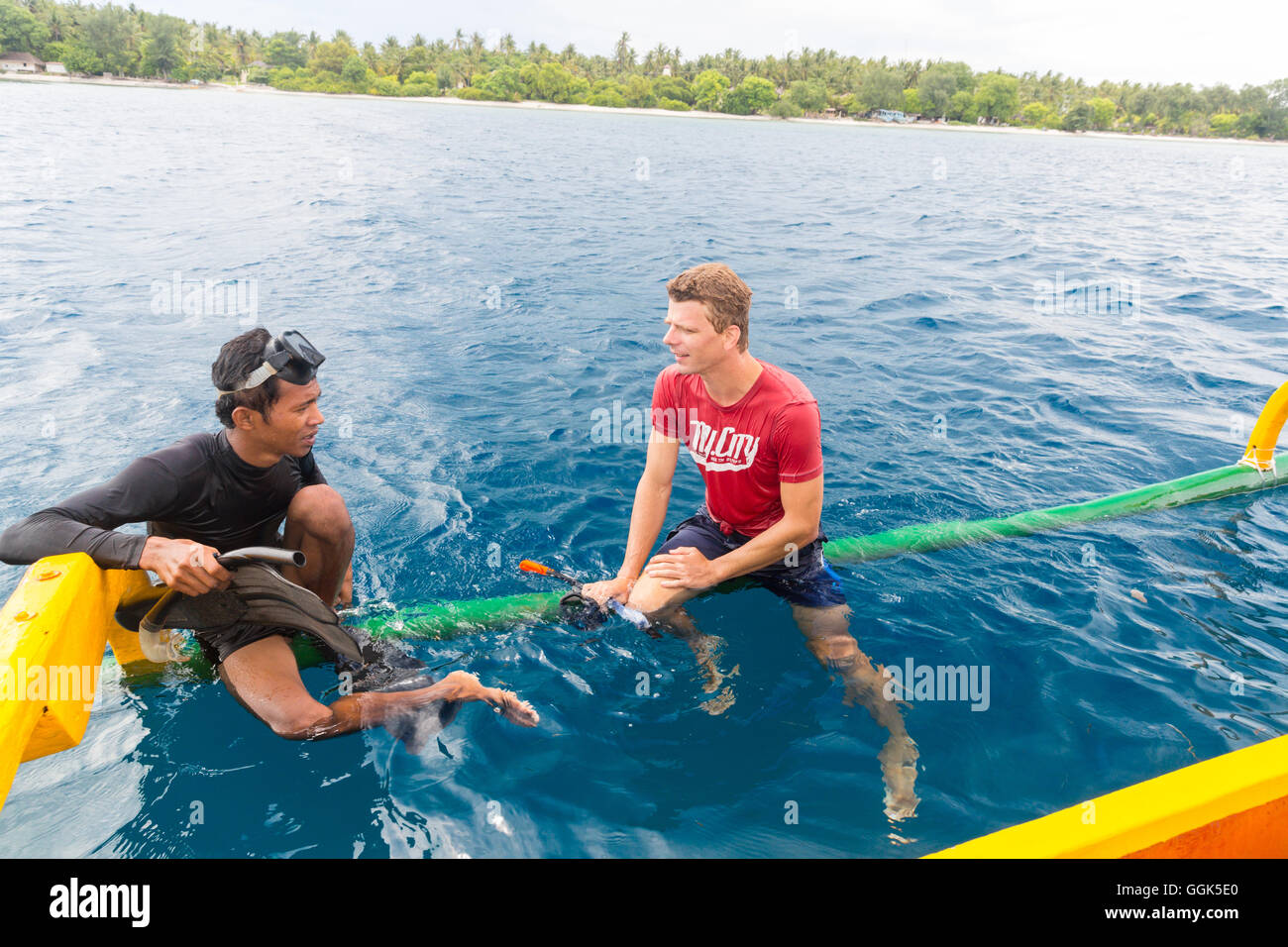 Indonesisch und Deutsch Mann im Wasser, Schnorchel, Schnorchel-Tour, traditionellen Boot, sitzen auf Balken, Kontakt mit der lokalen Bevölkerung Stockfoto