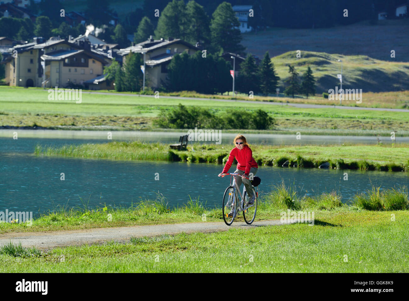 Frau Radfahren entlang See Champfèr, Silvaplana, Oberengadin, Kantons Graubündens, Schweiz Stockfoto