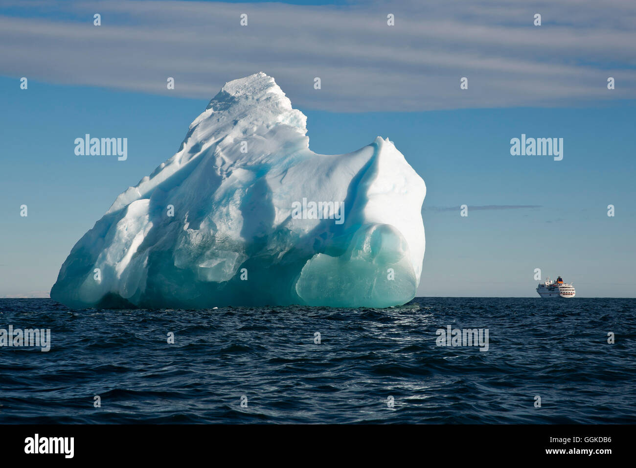Eisberg in hellem Sonnenlicht mit Expedition Kreuzfahrtschiff MS Hanseatic (Hapag-Lloyd Kreuzfahrten) im Hintergrund, Vogel Punkt, Ross Stockfoto