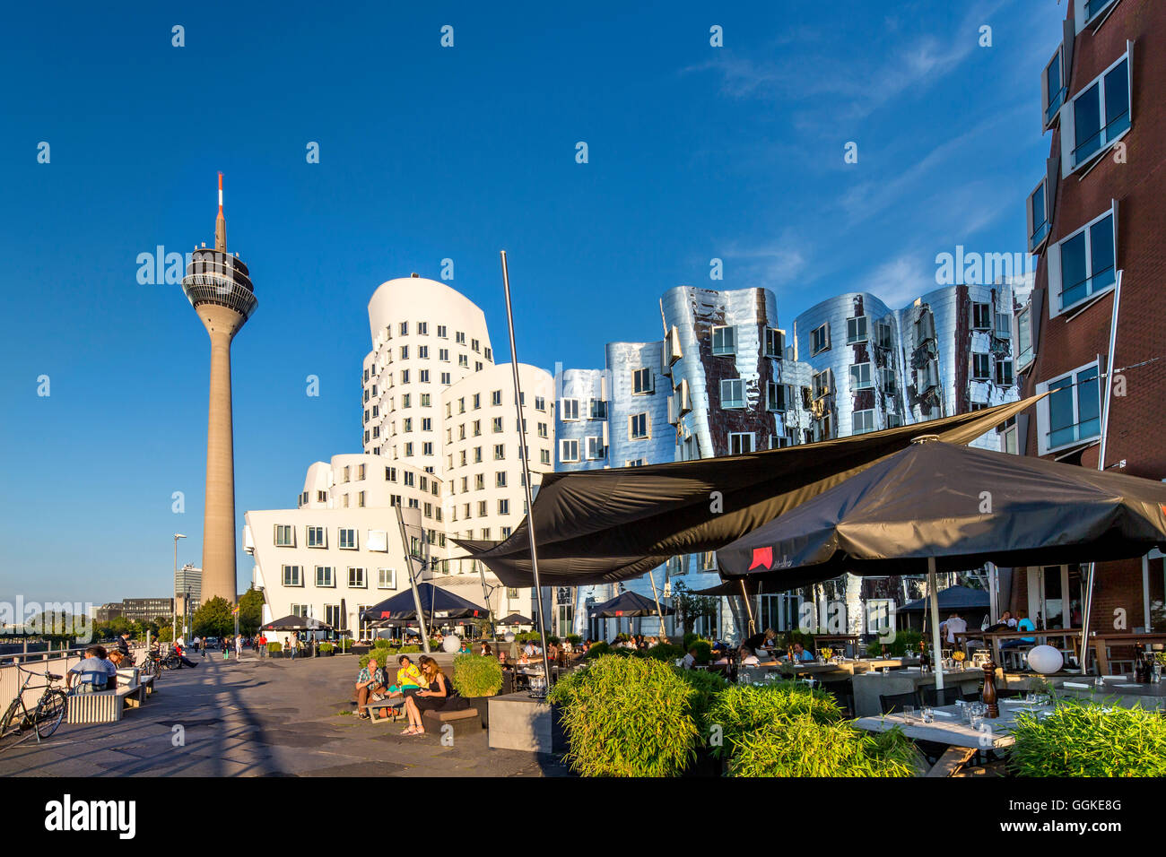 Cafe mit Frank Gehry-Bauten im Hintergrund, Neuer Zollhof, Medien-Hafen, Düsseldorf, Nord Rhein Westfalen, Deutschland Stockfoto