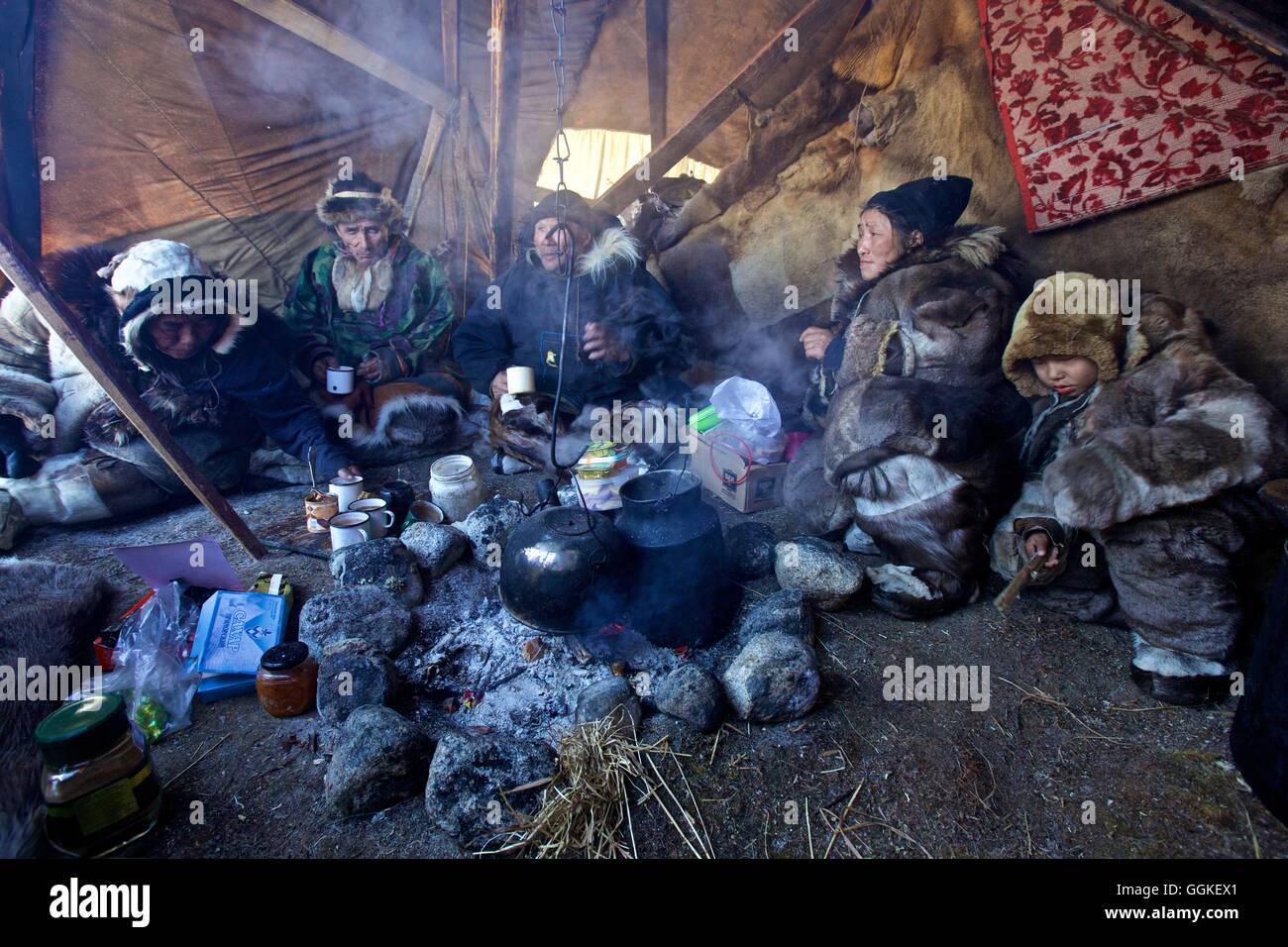 Rentenempfängers Nomad Familie um das Feuer in der Tschottagin, die Markise Yaranga, Chukotka autonomes Okrug, Sibirien, Russland Stockfoto